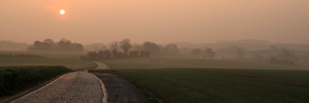 Lever de soleil brumeux sur une petite route entre Waterloo et Ohain